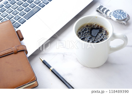 ノートパソコンでデスクワークの合間に、淹れたてのコーヒーでコーヒーブレイクを楽しんでいるイメージ 118489390