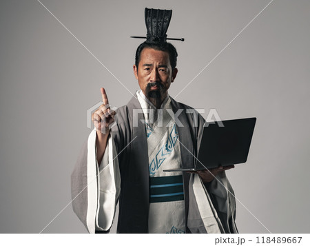 三国志に登場するような中国歴史上の偉人がノートパソコンを持って説明するシーン 118489667