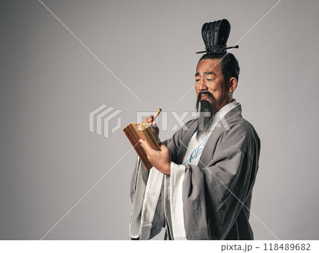 三国志に登場するような中国歴史上の偉人が竹簡に筆で漢文を書くシーン 三国志に登場するような中国歴史上の偉人が竹簡に筆で漢文を書くシーン 118489682