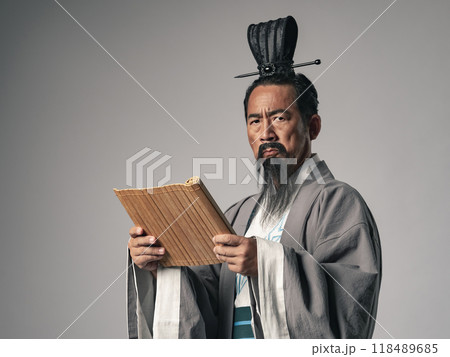 三国志に登場するような中国歴史上の偉人が竹簡の文書を読むシーン 118489685