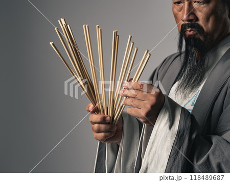 筮竹を使って易占いをする漢服を着た男性 118489687