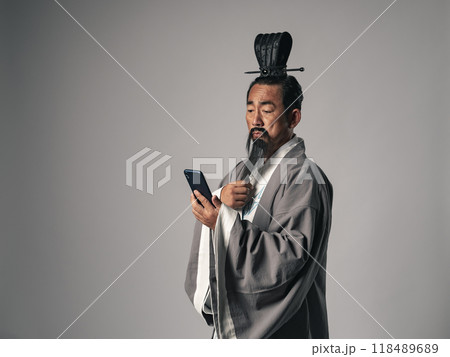 三国志に登場するような中国歴史上の偉人がスマホを見るシーン 三国志に登場するような中国歴史上の偉人がスマホを見るシーン 118489689