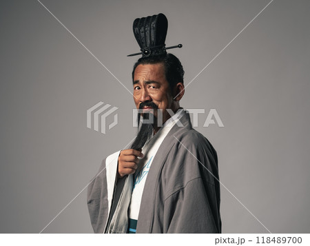 三国志に登場するようなニヤリと笑う漢服を着た中国歴史上の偉人のポートレート 118489700