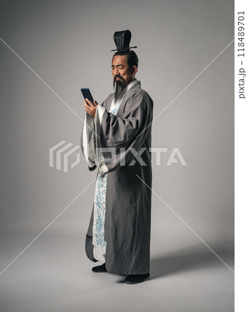 三国志に登場するような中国歴史上の偉人がスマホを見るシーン 118489701