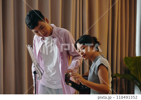 Practicing Together in Music Room with Sheet Music Stand Practicing Together in Music Room with Sheet Music Stand 118491352