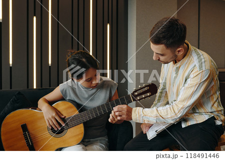 Teaching Acoustic Guitar to Young Student in Studio Teaching Acoustic Guitar to Young Student in Studio 118491446