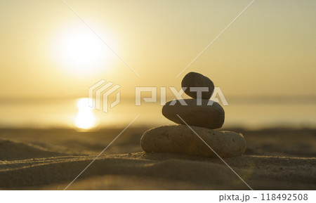 Zen stones background. Pyramid of stones on the background of sunset on the sea beach. Relax, balance, calm, concept. 118492508