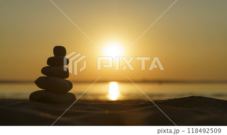 Zen stones background. Pyramid of stones on the background of sunset on the sea beach. Relax, balance, calm, concept. 118492509
