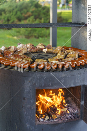 BBQ grill with meat and sausages on fire. Meat is fried on the grill 118492532