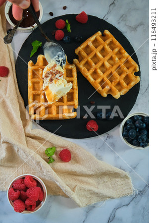 still life Belgian waffles on a black round plate 118493211