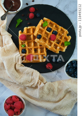 still life Belgian waffles on a black round plate 118493212