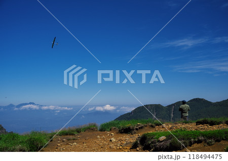 夏の毛無峠にて上昇気流に乗って飛ぶグライダーと操縦者 夏の毛無峠にて上昇気流に乗って飛ぶグライダーと操縦者 118494475