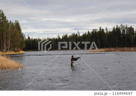 calm river in the north of Sweden. Man trying to catch 118494697