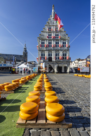 the town hall in the Netherlands and cheeses standing in front of it the town hall in the Netherlands and cheeses standing in front of it 118494762