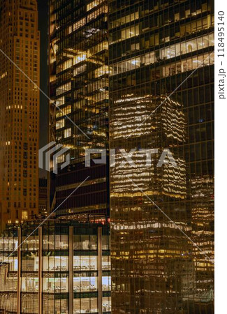 Nighttime city bulding architecture closeup glowing windows reflection 118495140