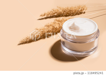 Jar of nourishing cream with natural dry grass 118495241
