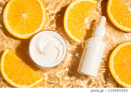 Cosmetic products in yellow water background with orange citrus 118495303