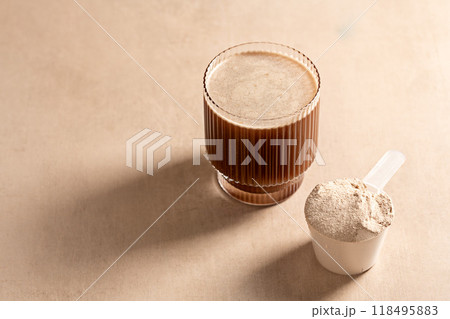 Chocolate protein powder in a measuring scoop. Nutrition and food supplement 118495883