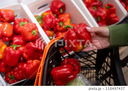 Customer choosing red pepper in supermarket 118497437