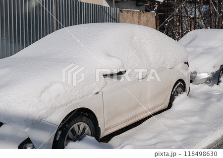 Car on a street covered with big snow layer. Car on a street covered with big snow layer. 118498630