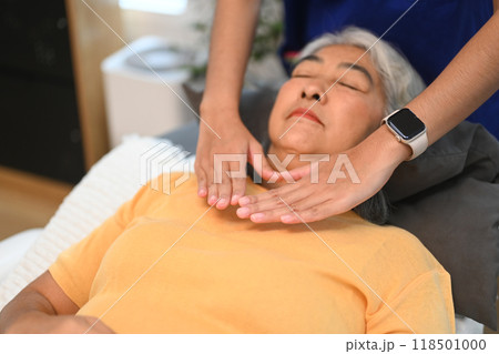 Senior woman having Reiki healing treatment with therapist. Alternative medicine and Reiki technique concept 118501000
