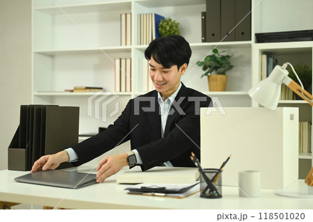 Handsome young businessman in formal suit working with laptop at office Handsome young businessman in formal suit working with laptop at office 118501020