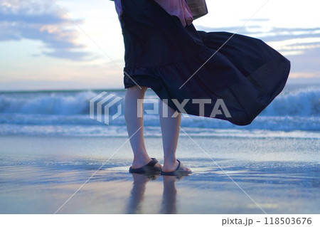 夕焼けの海を背景にした女性のポートレート 118503676