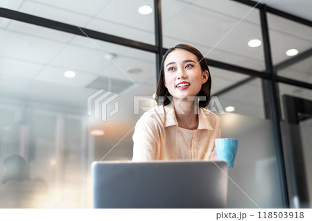 休憩の合間に遠くの景色を見て目の疲れを紛らわそうとしている女性 118503918