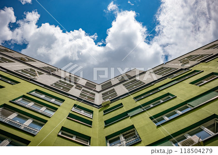 Green apartment building facade reaching up to the clouds on a sunny day Green apartment building facade reaching up to the clouds on a sunny day 118504279