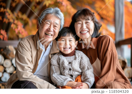秋を楽しむ笑顔の日本人家族（ファミリー・祖父母・孫・子供・両親・紅葉狩り・秋服・モデル・紅葉） 118504320
