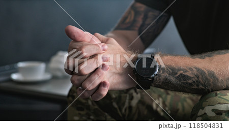 Close up of nervous military man clenching hands during therapy session 118504831