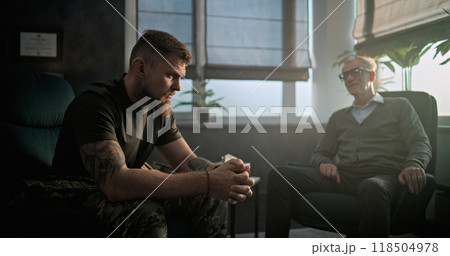 Depressed military man with PTSD talks to specialist on counseling session Depressed military man with PTSD talks to specialist on counseling session 118504978