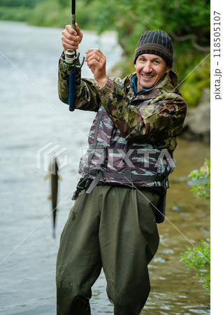 The fisherman caught a fish with a spinning rod The fisherman caught a fish with a spinning rod 118505107