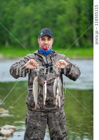 A fisherman shows his catch in a fish trap 118505115