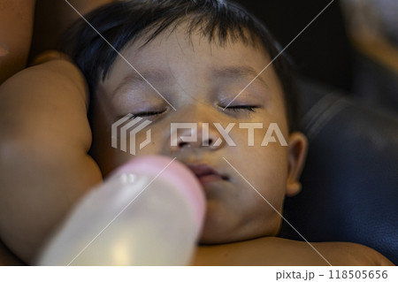 Baby falls asleep while drinking from a baby bottle. 118505656