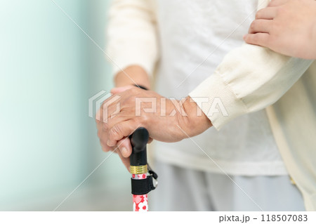 杖を持つシニア女性と介護士の手元 杖を持つシニア女性と介護士の手元 118507083