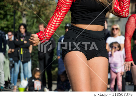 closeup of young woman dancing in the street with a black shorty closeup of young woman dancing in the street with a black shorty 118507379