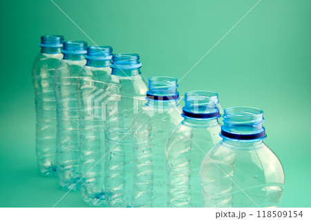 Plastic bottles in a row on a green background Plastic bottles in a row on a green background 118509154