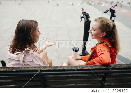 Having Conversation on Park Bench with Scooters Nearby Having Conversation on Park Bench with Scooters Nearby 118509155