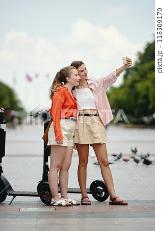 Taking Selfie with Friend on Sunny Day Outdoors Taking Selfie with Friend on Sunny Day Outdoors 118509170