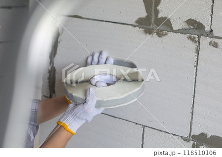 The craftsman works with construction tape for sealing. The craftsman works with construction tape for sealing. 118510106