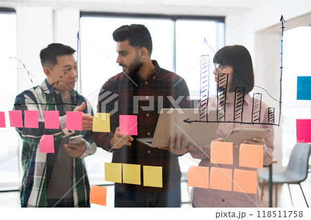 Business team brainstorming ideas with sticky notes and charts 118511758
