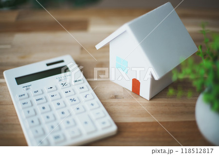 立体的な白い住宅模型と電卓 118512817