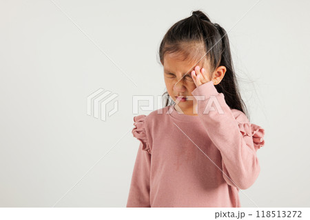 Portrait of Asian young kid girl sad tired strain face holding hold head by hands, stress kindergarten child person unhappy closed eyes problem headache, studio shot isolated on white background Portrait of Asian young kid girl sad tired strain face holding hold head by hands, stress kindergarten child person unhappy closed eyes problem headache, studio shot isolated on white background 118513272