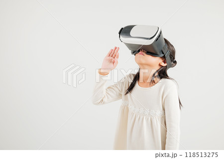 Portrait Asian smiling kid girl touching at something in a virtual reality glasses headset studio shot isolated white background, Excited happy kindergarten child using VR play simulation game 118513275
