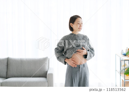 自分のお腹をさわる女性 自分のお腹をさわる女性 118513562