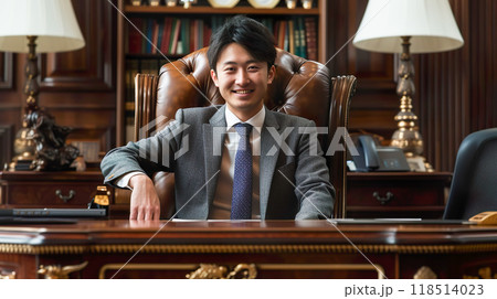 笑顔で豪華な部屋の椅子に座る若い経営者 笑顔で豪華な部屋の椅子に座る若い経営者 118514023