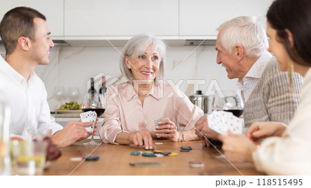 Senior woman playing poker with husband and adult children 118515495