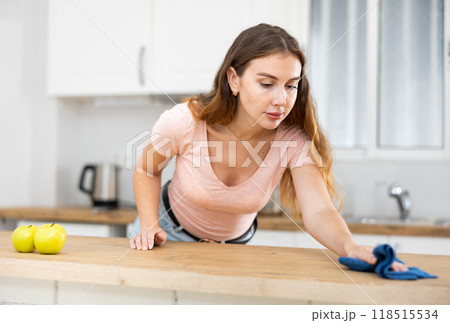 Young woman doing wet cleaning of the kitchen 118515534