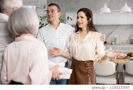 Young couple hospitably greeting elderly parents at home 118515597